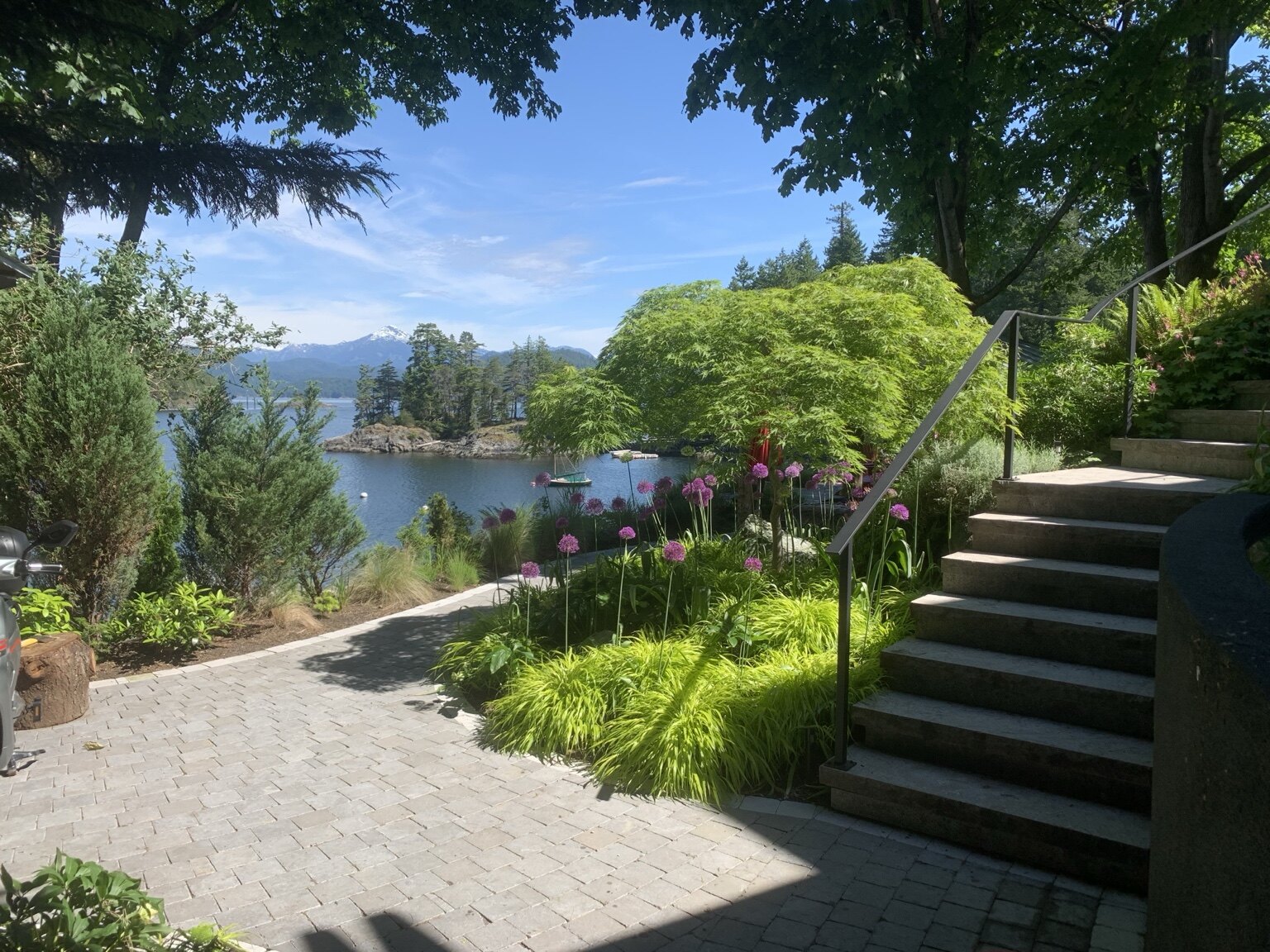 Irrigated waterfront garden with stone paths and coastal mountain views on Bowen Island